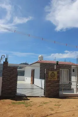 a building with a sign in front of it at THE DEW stay Three bedroom villa in Kodaikānāl