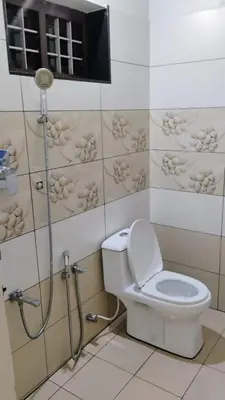 a bathroom with a toilet and a shower in it at Cozy Corner in Alwaye