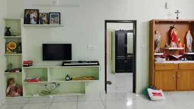 a living room with a tv on a wall at Cozy Corner in Alwaye
