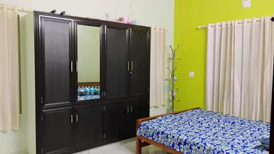 a bedroom with a large black cabinet and a bed at Cozy Corner in Alwaye