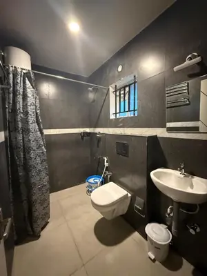 a bathroom with a toilet and a sink at Humming Bird suite in Kotagiri