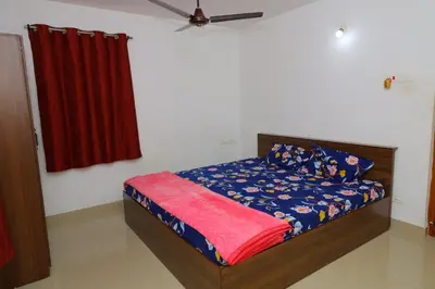 a bedroom with a bed and a red curtain at Coimbatore's Chettinad Courtyard By Shivalaya Stays in Alāndurai