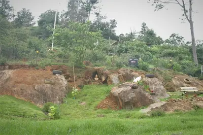 a park with rocks and a bench on a hill at Casa by the hills in Kotagiri