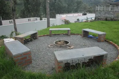 two picnic tables and a fire pit in a yard at Casa by the hills in Kotagiri