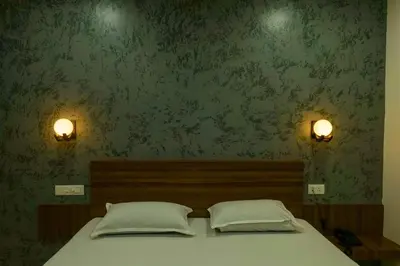 a bed with two pillows in a bedroom with green wallpaper at Balu Residency - A Business Class Hotel in Coimbatore