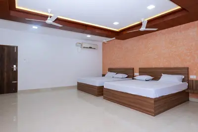a bedroom with two beds and a wall at Balu Residency - A Business Class Hotel in Coimbatore