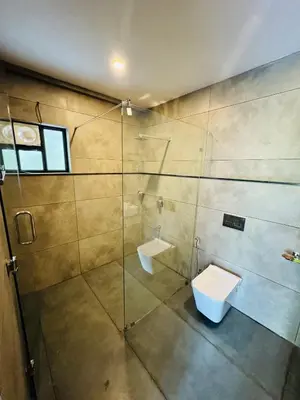 a bathroom with a glass shower and a toilet at AYD-IN BY GREENLEAVES Resort in Vythiri