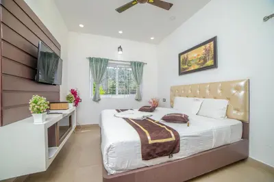 a bedroom with a bed with a desk and a television at Royal Crown in Kotagiri