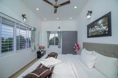 a bedroom with a bed and a ceiling fan at Royal Crown in Kotagiri
