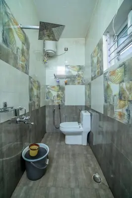 a bathroom with a toilet and a sink at Royal Crown in Kotagiri