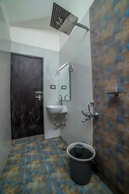 a bathroom with a sink and a toilet and a mirror at Royal Crown in Kotagiri