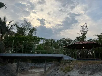 a bridge over a beach with a umbrella on it at Jungle flare in Hampāpura