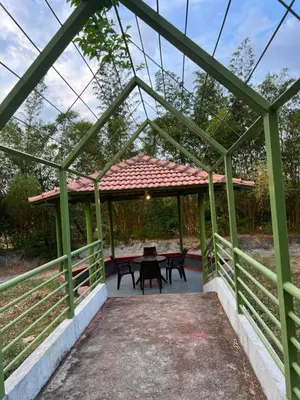 a green pergola with a picnic table on a patio at Jungle flare in Hampāpura