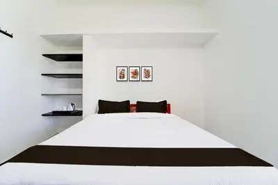 a bedroom with a white bed and shelves at Super Hotel O Neelambur Near PSG ITech in Coimbatore