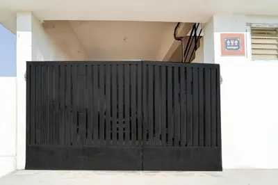 a black gate in front of a white building at Super Hotel O Neelambur Near PSG ITech in Coimbatore