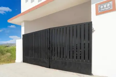 a black gate on the side of a white building at Super Hotel O Neelambur Near PSG ITech in Coimbatore