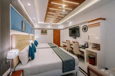 a hotel room with a bed and a dining room at Excellency Airport Hotel in Angamali