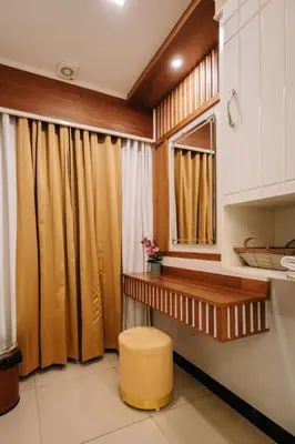 a bathroom with brown curtains and a stool at Excellency Airport Hotel in Angamali