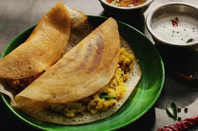 a green plate of food with two pita bread and dip at Super Hotel O Tiruppur Near Railway station in Tiruppūr