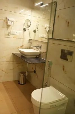 a bathroom with a white toilet and a sink at Mysore Elite in Mysore