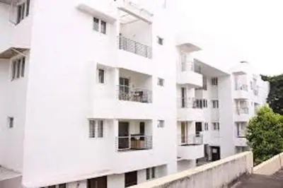 a white building with balconies on the side of it at Horizon Heights Apartment in Coimbatore