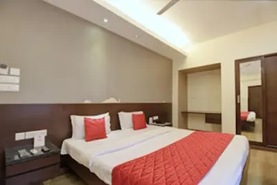 a bedroom with a large bed with red pillows at Horizon Heights Apartment in Coimbatore