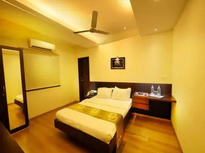 a hotel room with a bed and a mirror at Horizon Heights Apartment in Coimbatore