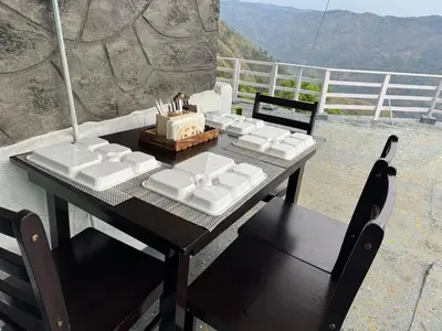 a table and chairs with a box on it at The Plum Castle in Kodaikānāl