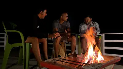 a group of men sitting around a fire at The Plum Castle in Kodaikānāl