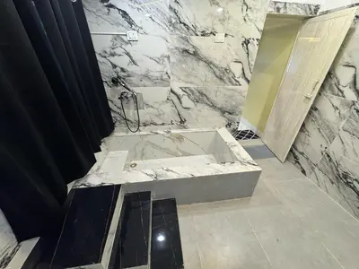 a marble bathroom with a tub and a shower at The Plum Castle in Kodaikānāl