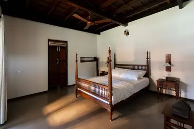 a bedroom with a bed with a wooden frame at Reverie in North Paravur