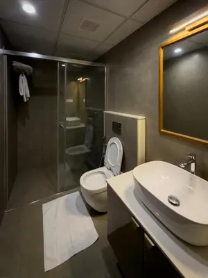 a bathroom with a toilet and a sink and a shower at Reverie in North Paravur