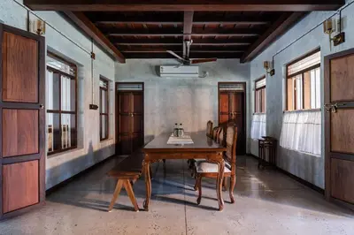 a dining room with a wooden table and chairs at Reverie in North Paravur