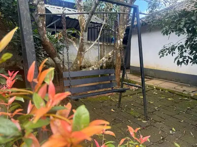 an empty swing in a garden with flowers at 2 Empire One Bedroom with Common Pool in Wayanad