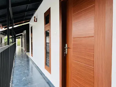 a wooden door on the side of a house at 2 Empire One Bedroom with Common Pool in Wayanad