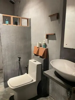 a bathroom with a white toilet and a sink at Rustic Nestle, Tirupur in Tiruppūr