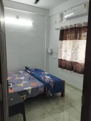 a small room with a bed and a window at Thrikarthika appartments in Guruvāyūr