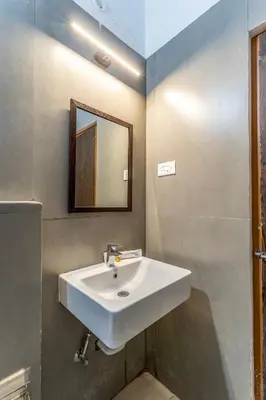 a bathroom with a white sink and a mirror at Finch,Kotagiri in Kotagiri