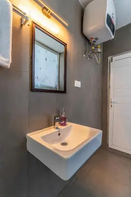 a bathroom with a white sink and a mirror at Finch,Kotagiri in Kotagiri
