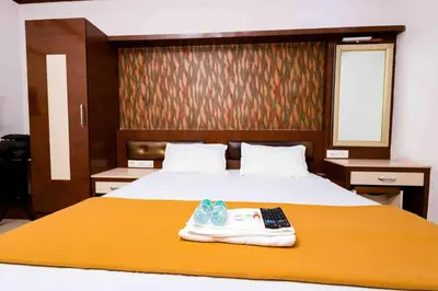 a hotel room with a bed with a remote control on it at Hotel DRG Heritage in Tiruppūr