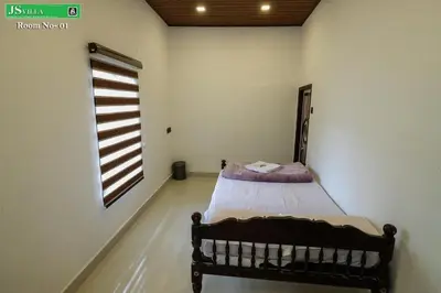 a bedroom with a bed in a room with a window at JS homes vattavada in Vattavada