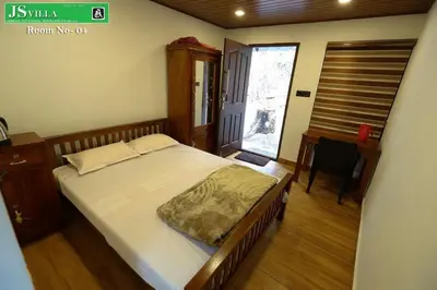 a bedroom with a bed and a desk and a window at JS homes vattavada in Vattavada