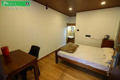 a room with a bed and a table and a desk at JS homes vattavada in Vattavada