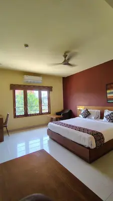 a large bedroom with a large bed and a window at Ambal Regency in Pudukād