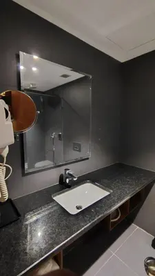 a bathroom counter with a sink and a mirror at Ambal Regency in Pudukād