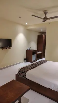 a hotel room with a bed and a flat screen tv at Ambal Regency in Pudukād