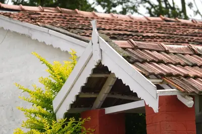 an attic window of a house with a roof at Estate Bungalow with Waterfall, Mountain & Valley Views in Kotagiri