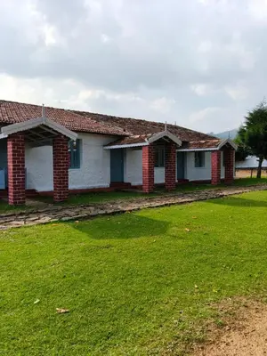 a house with a green lawn in front of it at Estate Bungalow with Waterfall, Mountain & Valley Views in Kotagiri