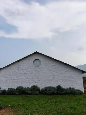 a white building with a window on the side of it at Estate Bungalow with Waterfall, Mountain & Valley Views in Kotagiri