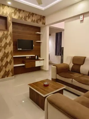 a living room with a couch and a tv at Airport Tree in Nedumbassery
